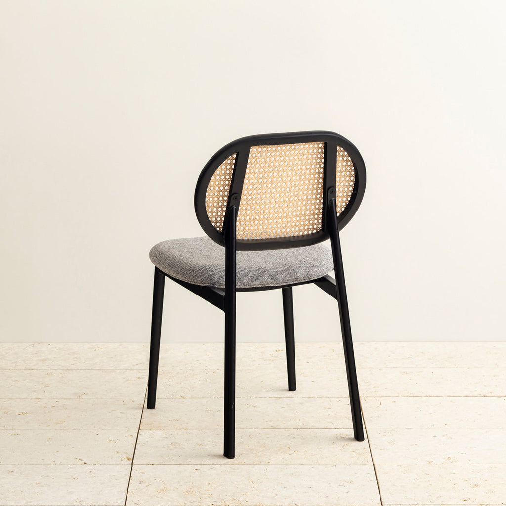 クラシカルなデザインの背もたれにダークグレーのファブリックと黒のスチール脚を組み合わせたレトロモダンなダイニングチェア（斜め後ろ）