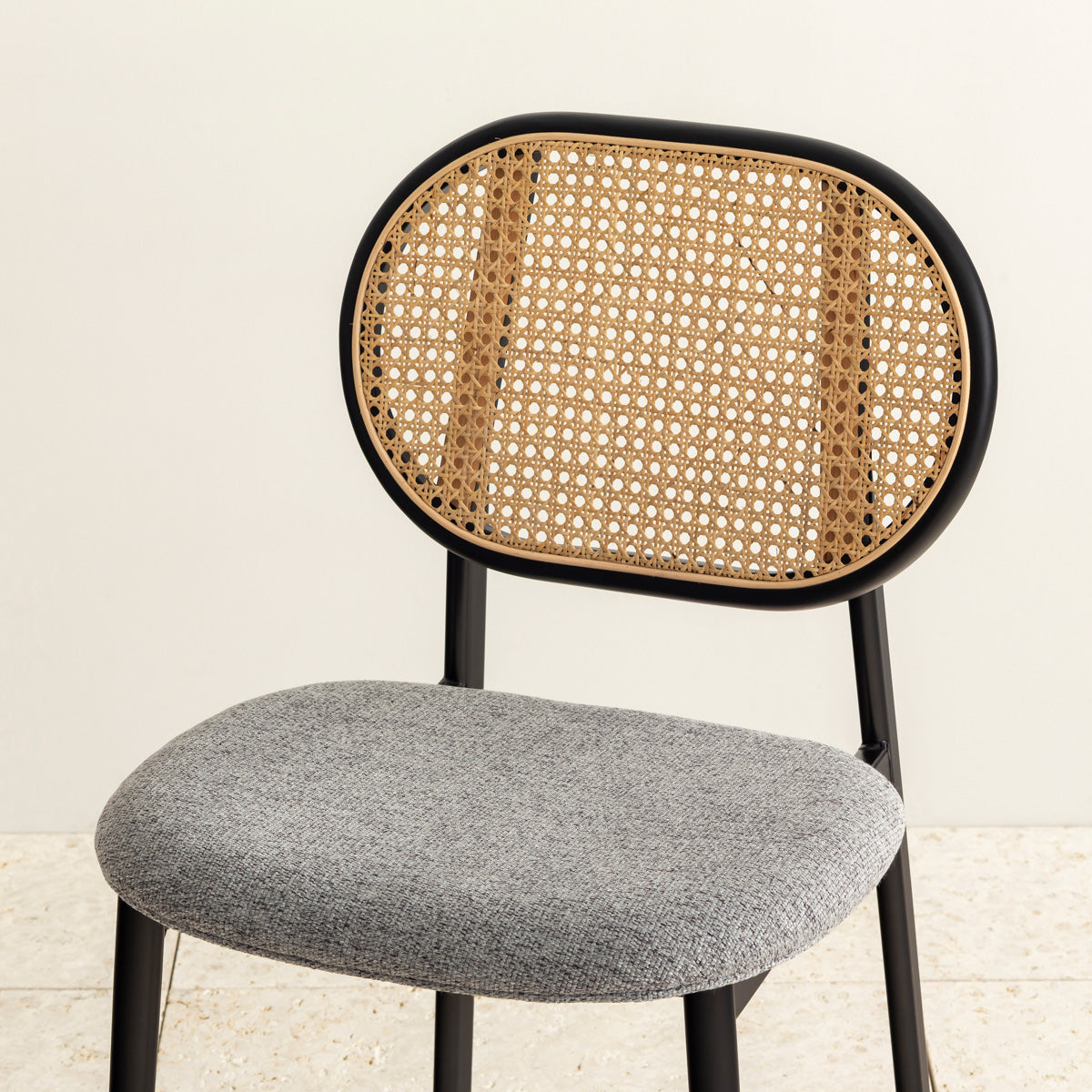 クラシカルなデザインの背もたれにダークグレーのファブリックと黒のスチール脚を組み合わせたレトロモダンなダイニングチェア（斜め向き・クローズアップ）