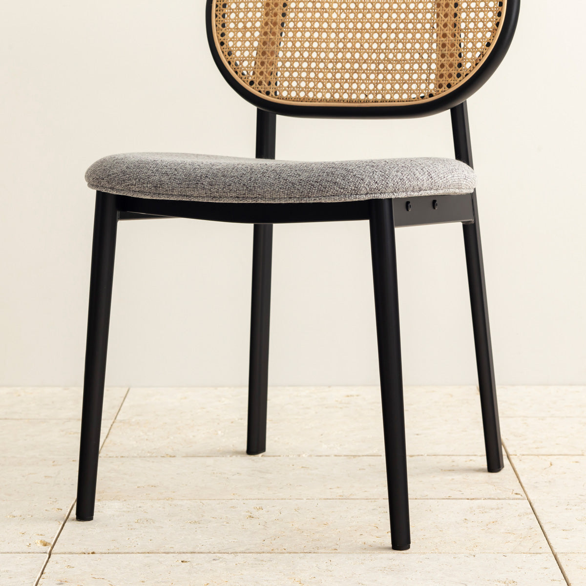 クラシカルなデザインの背もたれにダークグレーのファブリックと黒のスチール脚を組み合わせたレトロモダンなダイニングチェア（下部・クローズアップ）