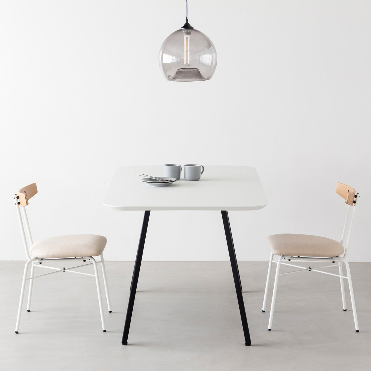 KanademonoのFENIX 天板ホワイトにマットブラックのスリムライン脚を組み合わせた、優れた性能と美しさを併せもつ新しいテーブル（ダイニング使用例）