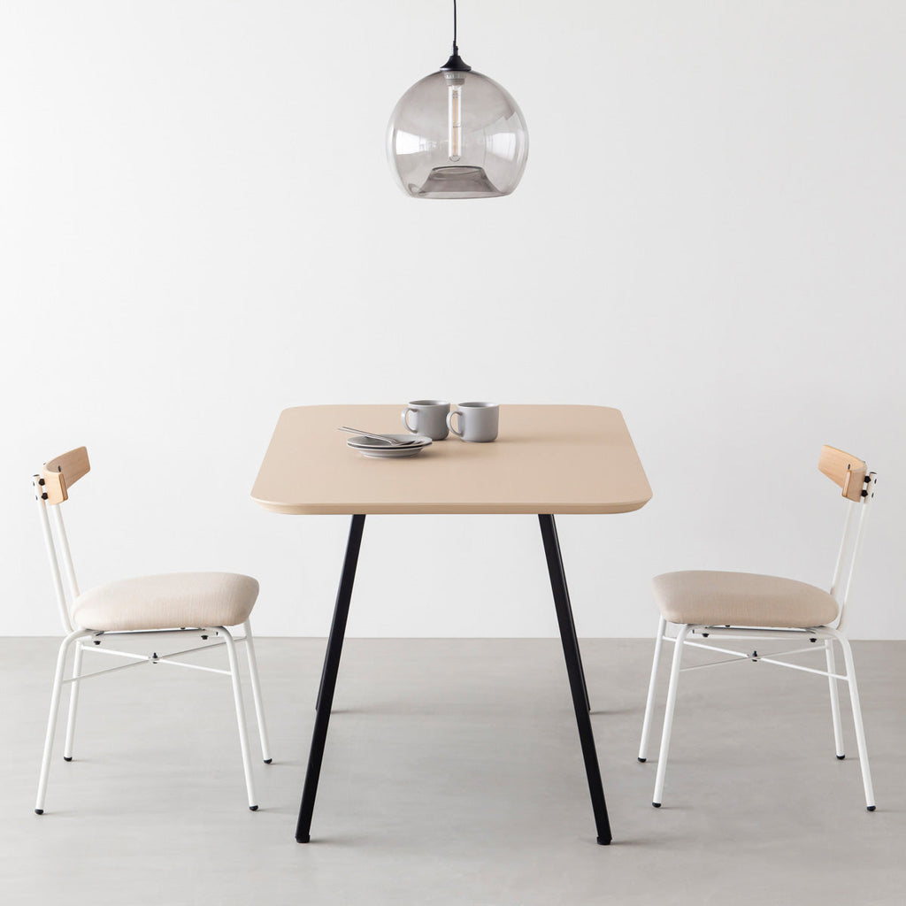 KanademonoのFENIX 天板ライトベージュにマットブラックのスリムライン脚を組み合わせた、優れた性能と美しさを併せもつ新しいテーブル（ダイニング使用例）