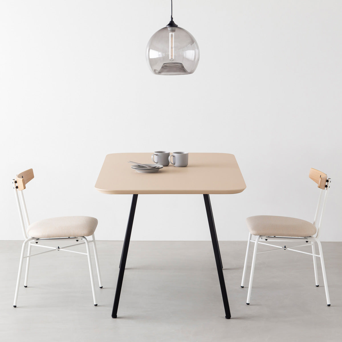 KanademonoのFENIX 天板ライトベージュにマットブラックのスリムライン脚を組み合わせた、優れた性能と美しさを併せもつ新しいテーブル（ダイニング使用例）