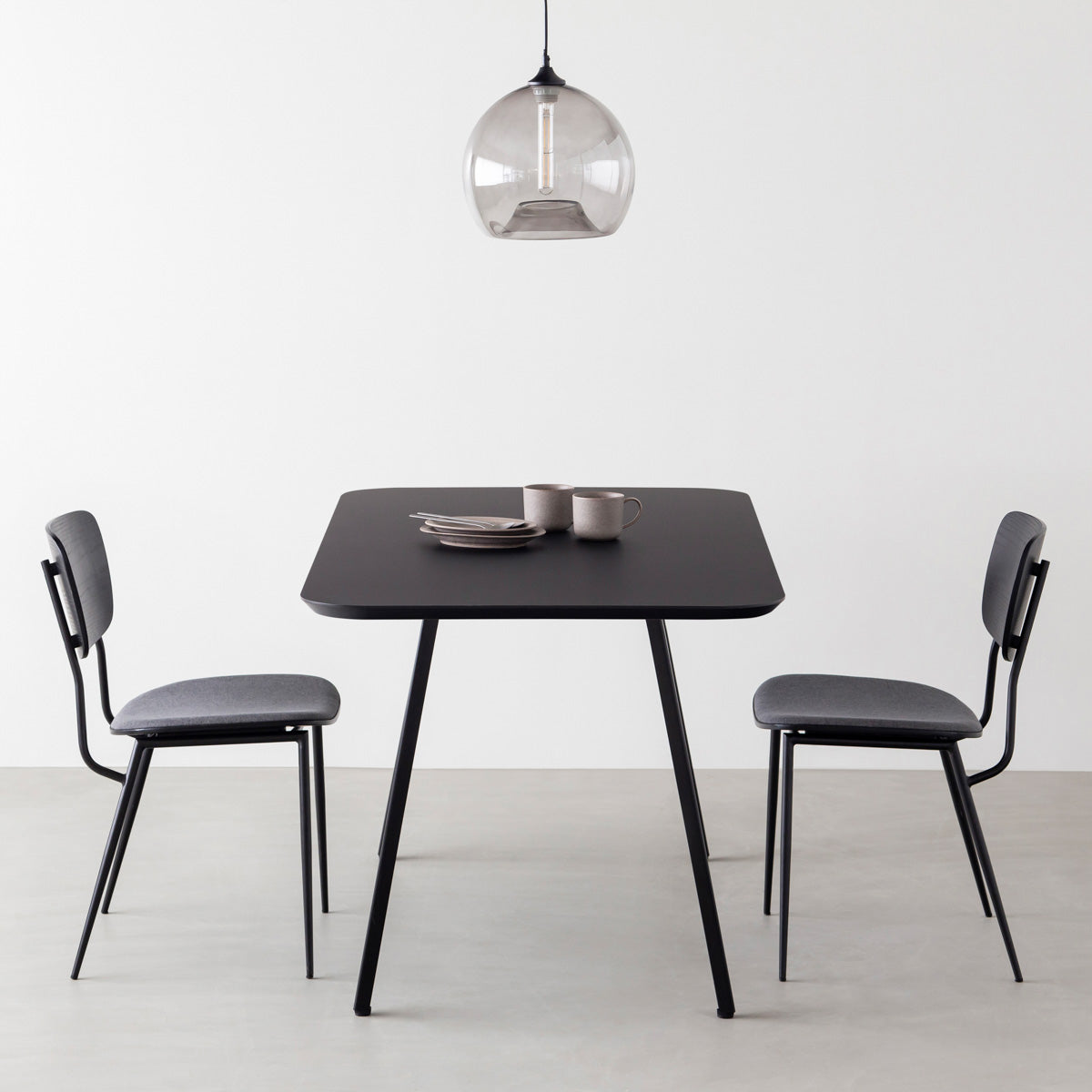 KanademonoのFENIX 天板ブラックにマットブラックのスリムライン脚を組み合わせた、優れた性能と美しさを併せもつ新しいテーブル（ダイニング使用例）