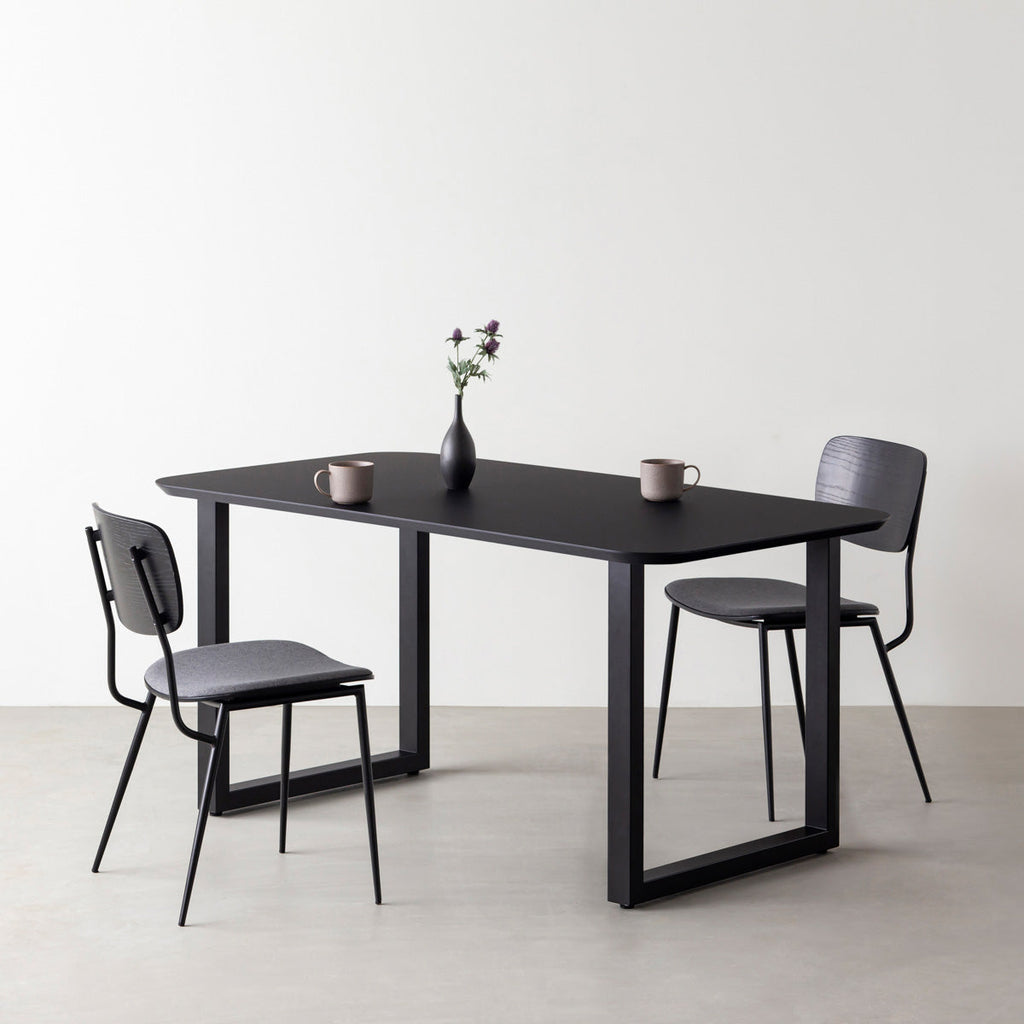 KanademonoのFENIX 天板ブラックにマットブラックのスクエア鉄脚を組み合わせた、優れた性能と美しさを併せもつ新しいテーブル（ダイニング使用例）