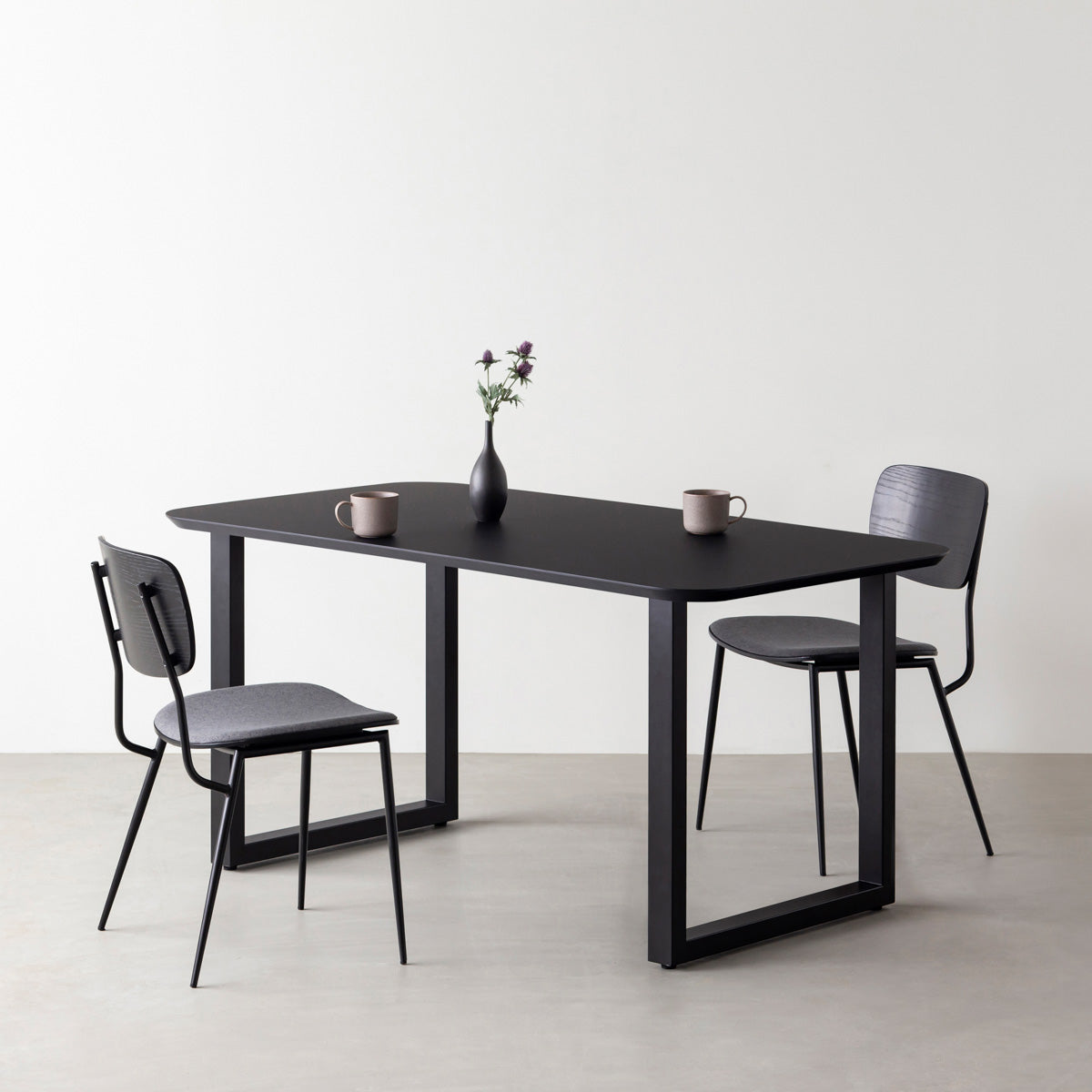 KanademonoのFENIX 天板ブラックにマットブラックのスクエア鉄脚を組み合わせた、優れた性能と美しさを併せもつ新しいテーブル（ダイニング使用例）