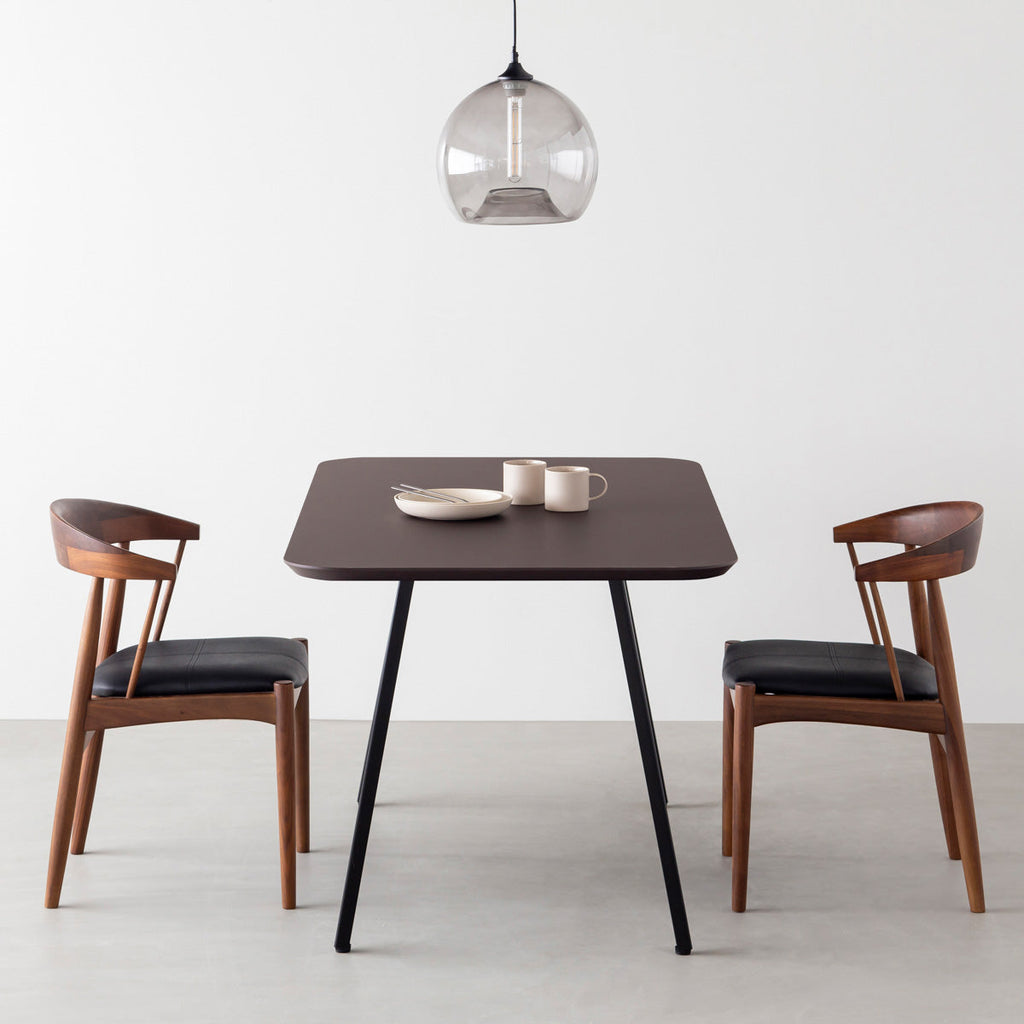 KanademonoのFENIX 天板ブラウンにマットブラックのスリムライン脚を組み合わせた、優れた性能と美しさを併せもつ新しいテーブル（ダイニング使用例）