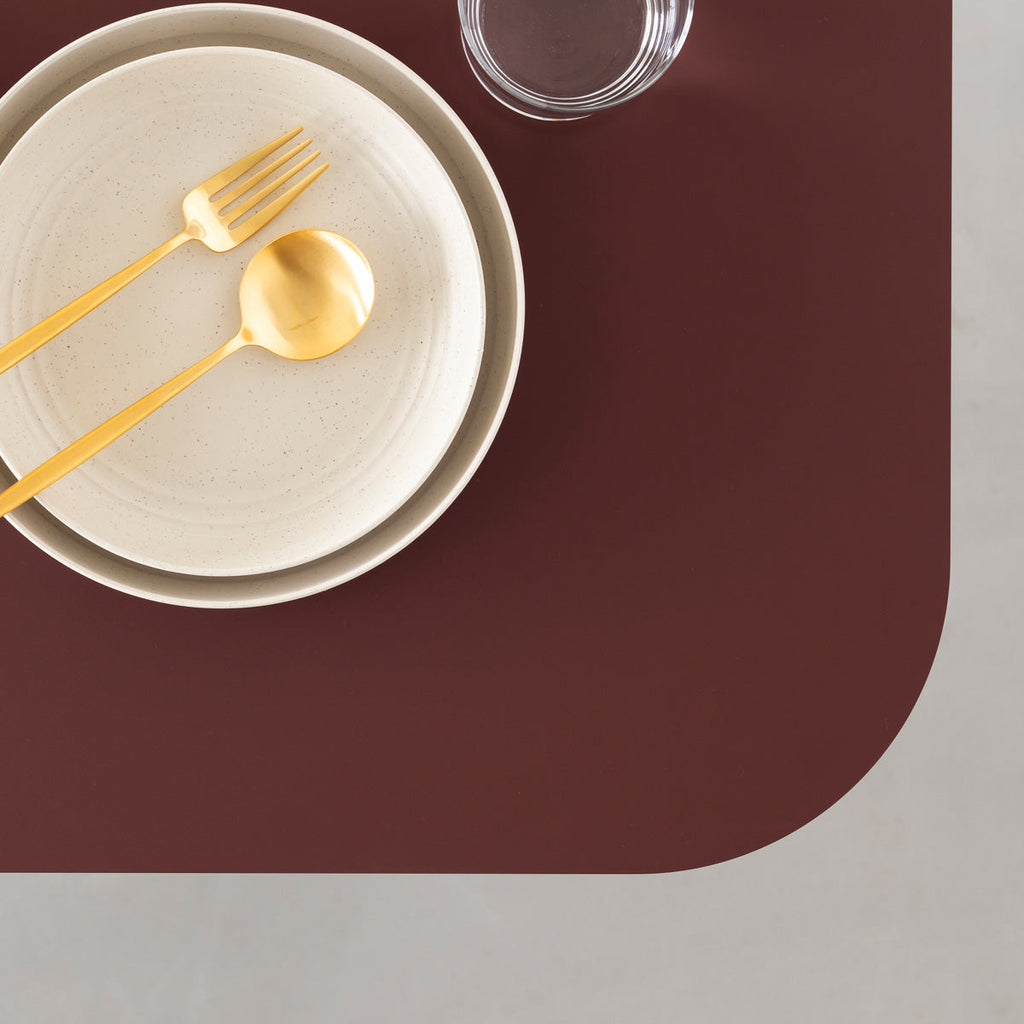 KanademonoのFENIX 天板ボルドーにマットブラックスクエア脚を組み合わせた、優れた性能と美しさを併せもつ新しいテーブル（ダイニング使用例3）