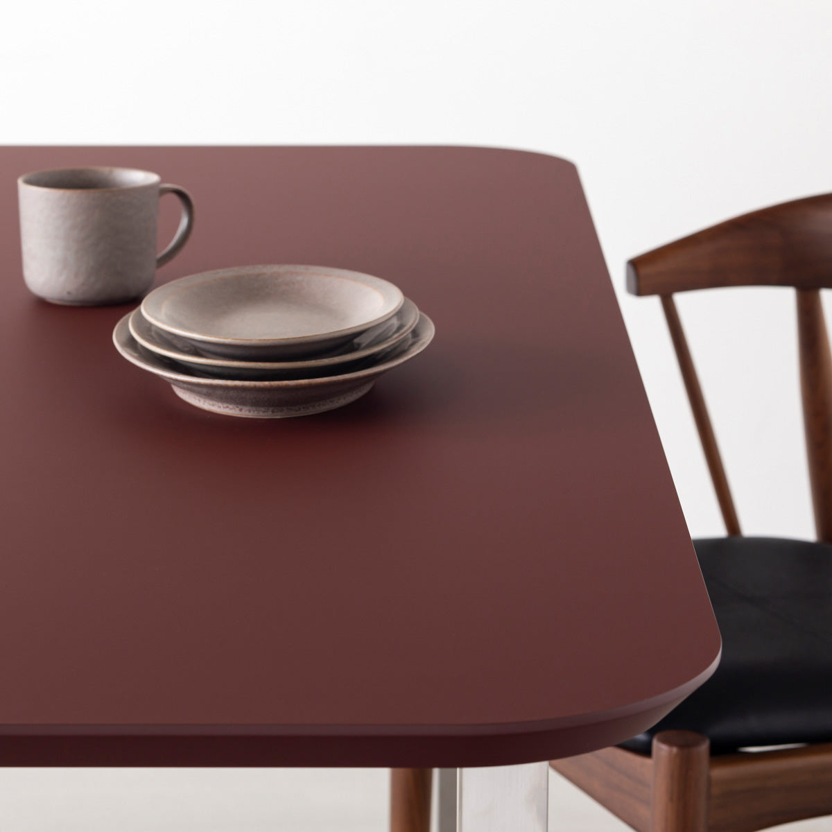 KanademonoのFENIX 天板ボルドーにマットブラックスクエア脚を組み合わせた、優れた性能と美しさを併せもつ新しいテーブル（ダイニング使用例2）