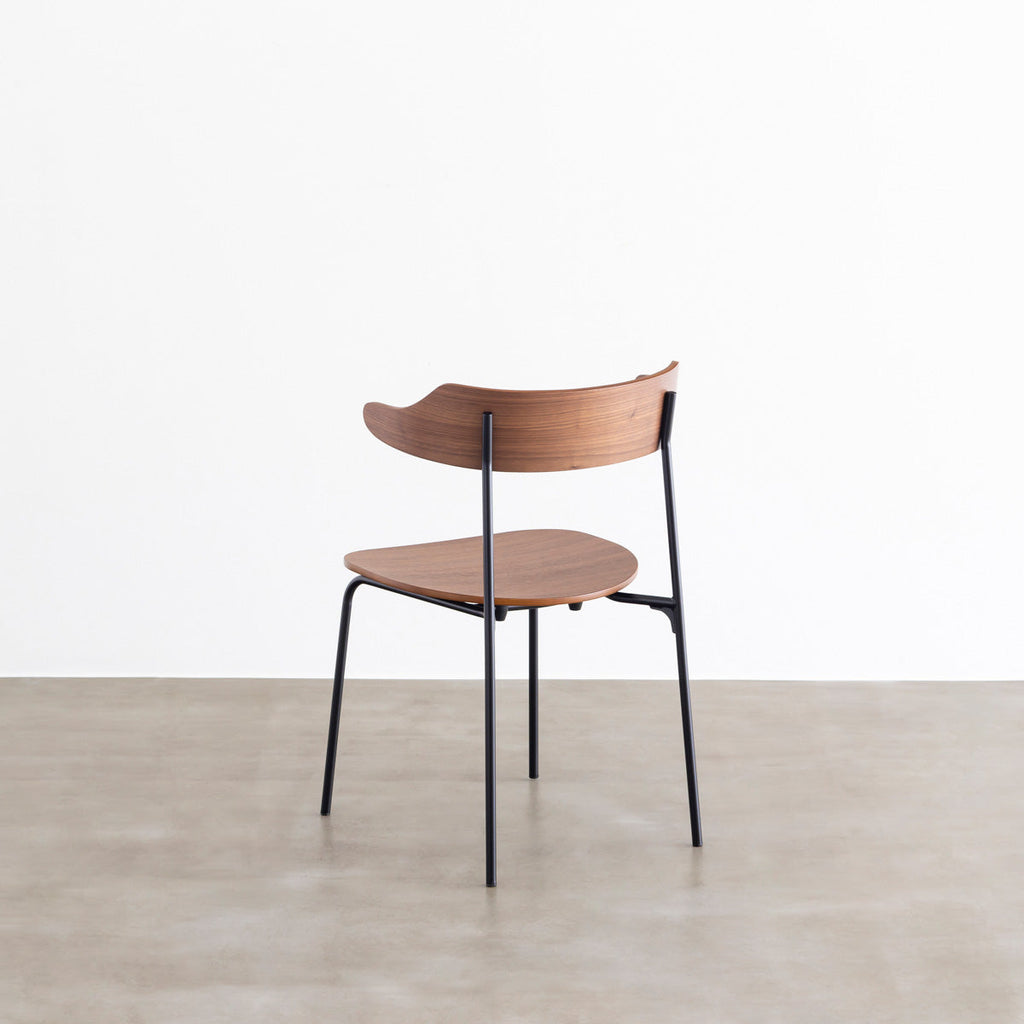 ウォールナット材プライウッドとスチールを組み合わせたブラウンのハーフアームの板座ダイニングチェア（斜め後ろ）